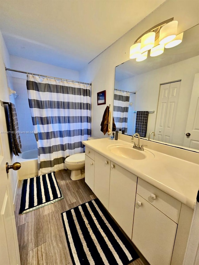 full bathroom with vanity, shower / bath combo, wood-type flooring, and toilet