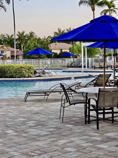 pool at dusk with a patio area