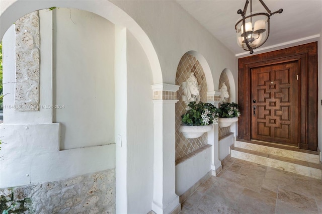 tiled entrance foyer with an inviting chandelier