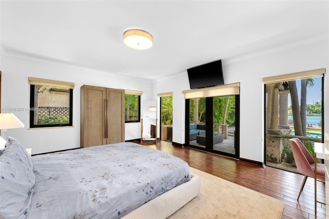 bedroom featuring dark hardwood / wood-style flooring, access to outside, and ornamental molding