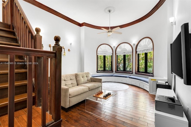 living room featuring ceiling fan, crown molding, hardwood / wood-style floors, and a high ceiling