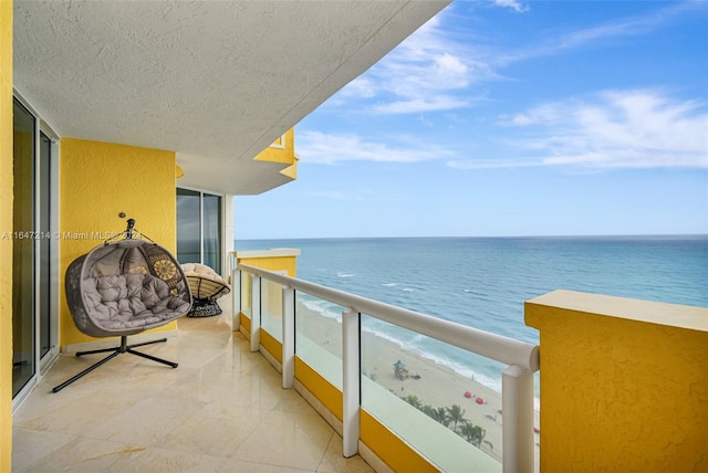 balcony with a water view and a beach view