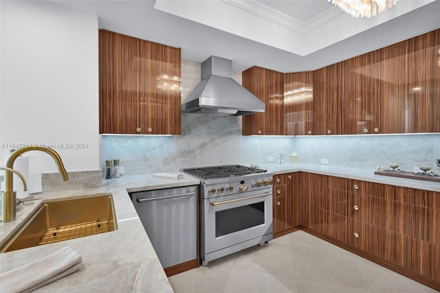 kitchen with backsplash, appliances with stainless steel finishes, wall chimney range hood, and sink