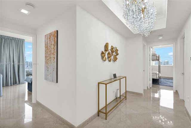 hallway featuring a notable chandelier and a wealth of natural light