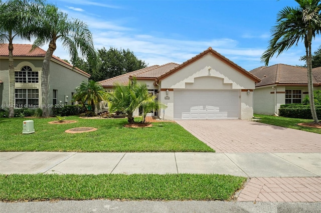 mediterranean / spanish house featuring a front yard and a garage