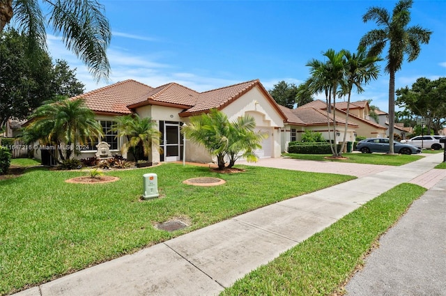 mediterranean / spanish-style home featuring a garage and a front lawn