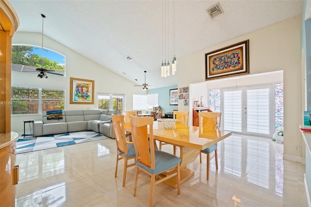 tiled dining space featuring a textured ceiling, ceiling fan, and high vaulted ceiling