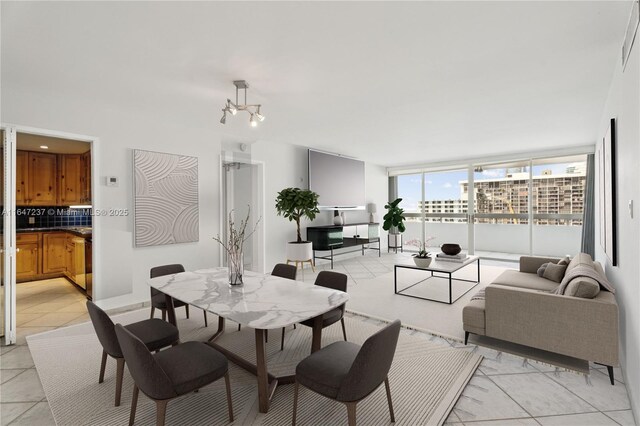 dining room with floor to ceiling windows and a notable chandelier