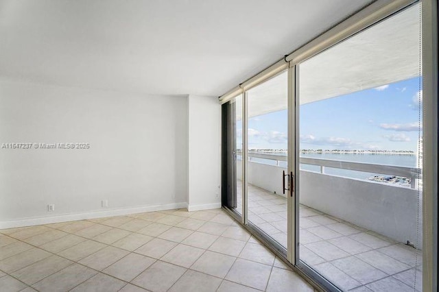 tiled spare room featuring a water view