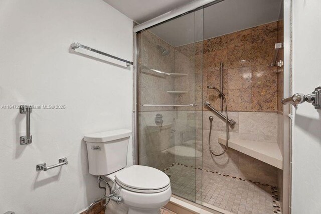 bathroom with an enclosed shower and toilet