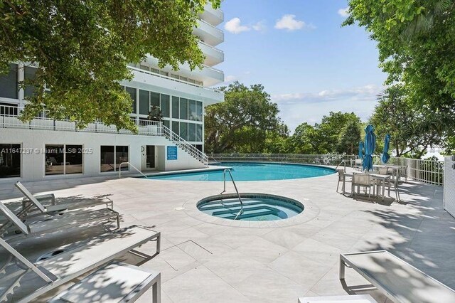 view of pool with a community hot tub and a patio