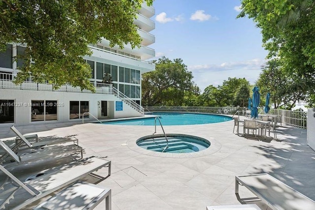 view of pool featuring a hot tub and a patio area