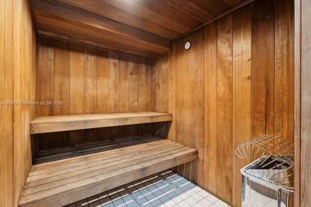 view of sauna with tile patterned floors, wooden ceiling, and wooden walls