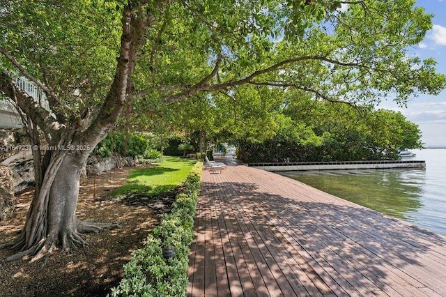 surrounding community with a boat dock and a water view