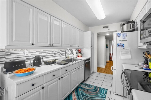 3598 Yacht Club Dr Unit 302, Aventura, FL 33180 - kitchen with a sink, stainless steel appliances, white cabinetry, and light tile patterned floors