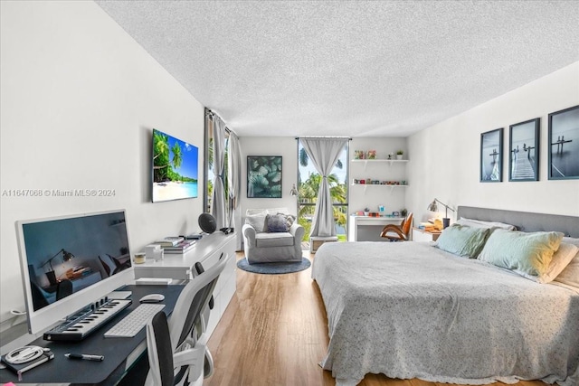 bedroom with hardwood / wood-style flooring and a textured ceiling