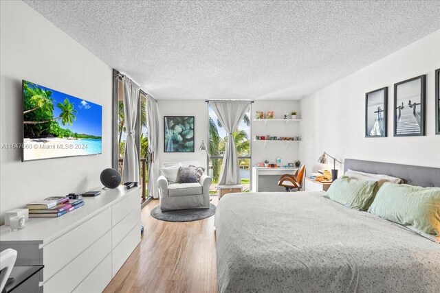 bedroom with light wood-style floors and a textured ceiling