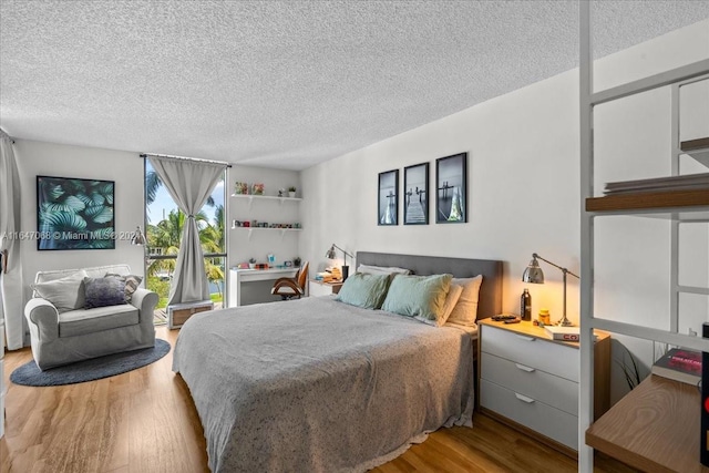 bedroom with light wood-type flooring and a textured ceiling