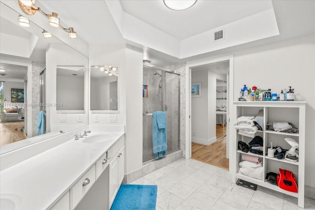 bathroom with tile patterned flooring, a shower with door, and vanity