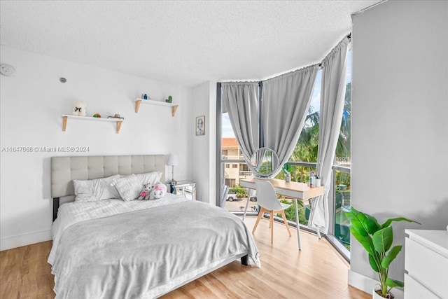 bedroom featuring light hardwood / wood-style floors and a textured ceiling