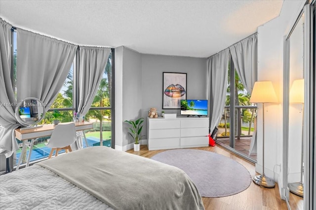 bedroom featuring a textured ceiling, light hardwood / wood-style floors, and access to outside