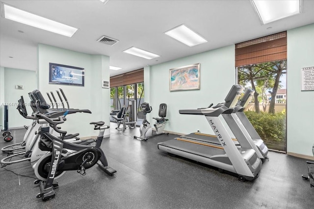 exercise room with baseboards and visible vents