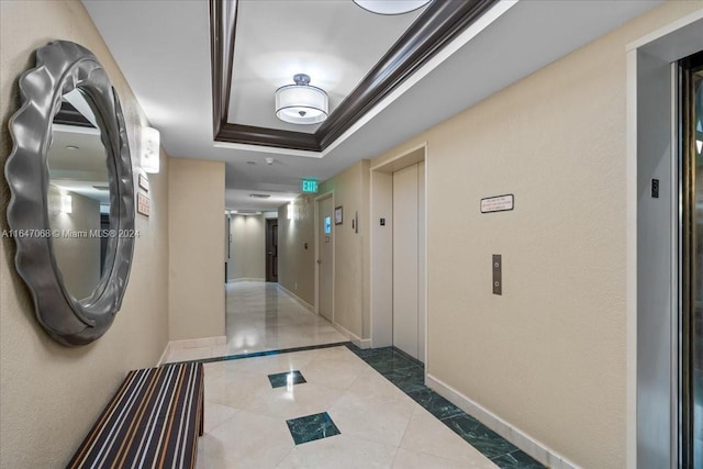 hallway featuring elevator, baseboards, and a raised ceiling