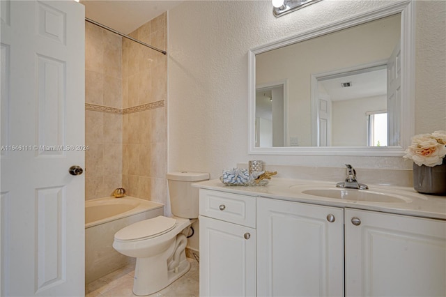 full bathroom featuring tile patterned floors, toilet, tiled shower / bath, and vanity