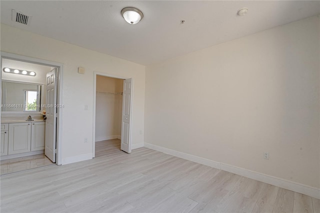 unfurnished bedroom with light wood-type flooring and a closet