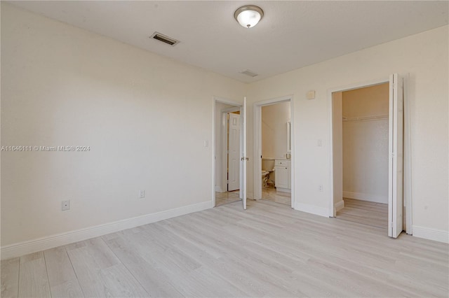 unfurnished bedroom with light wood-type flooring and a closet