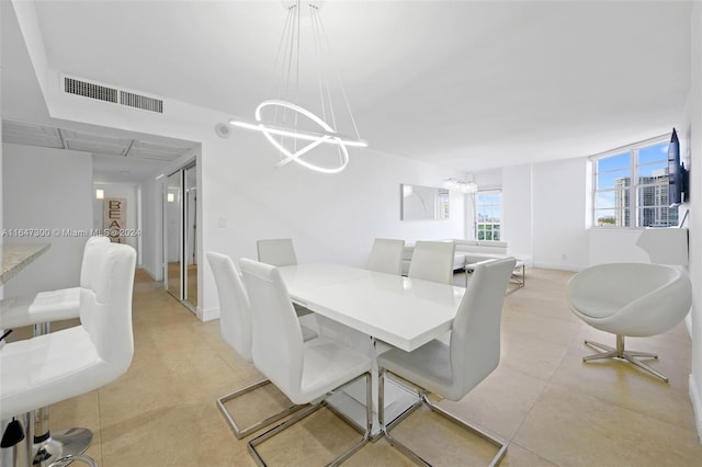 dining space featuring light tile patterned floors and a chandelier