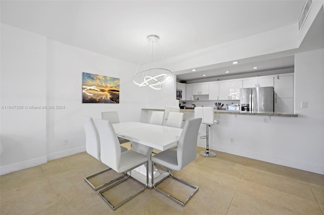 tiled dining space featuring an inviting chandelier