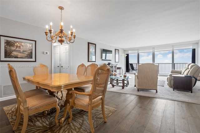 dining room with a wall of windows, wood-type flooring, visible vents, and an inviting chandelier