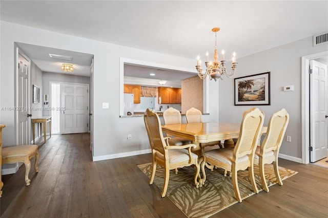 dining space featuring a chandelier, dark wood-style flooring, visible vents, and baseboards