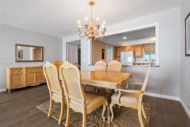 dining area with dark wood-type flooring and an inviting chandelier