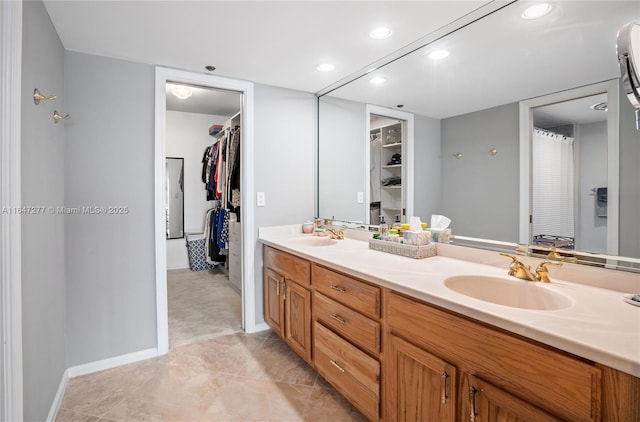 full bathroom with a walk in closet, a sink, and double vanity