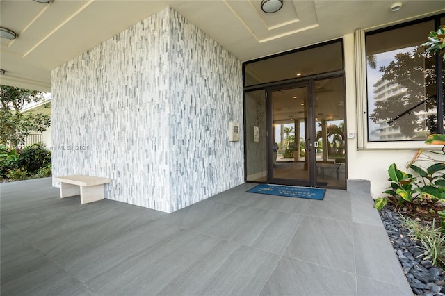 view of exterior entry with a patio and french doors