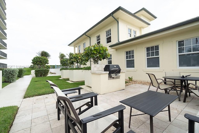 view of patio / terrace with outdoor dining space, an outdoor kitchen, and a grill