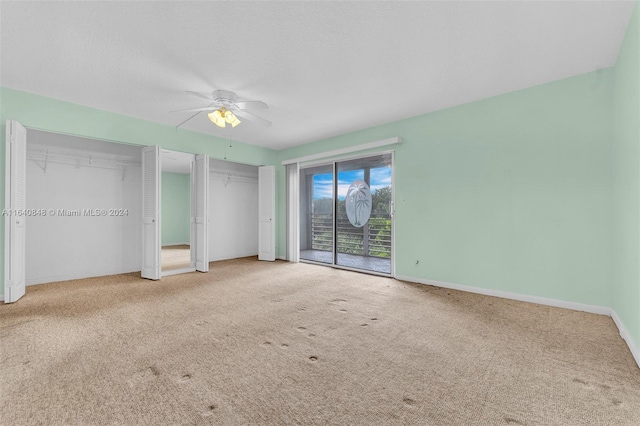 unfurnished bedroom with ceiling fan, two closets, light carpet, and access to exterior