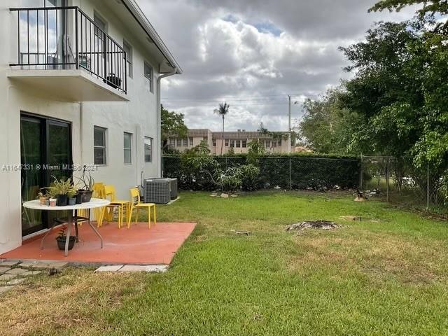 view of yard featuring a patio, a balcony, and central AC