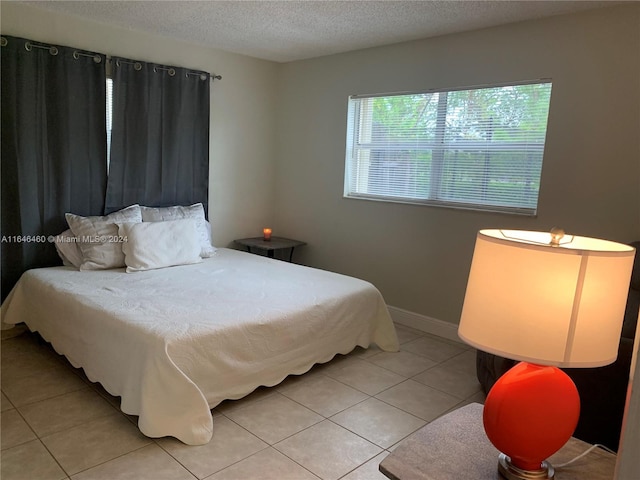 bedroom with light tile patterned flooring and a textured ceiling