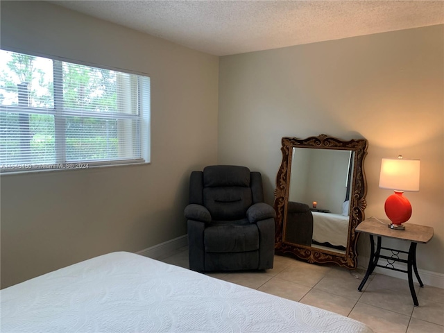 bedroom with light tile patterned floors and a textured ceiling