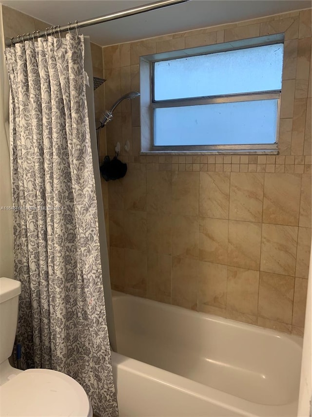 bathroom with toilet and shower / bath combo with shower curtain