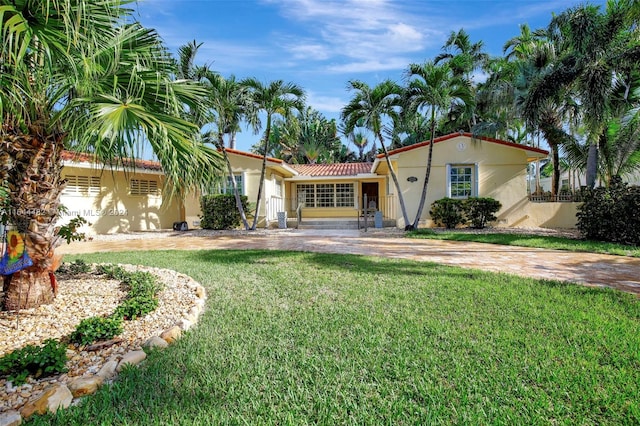 mediterranean / spanish home featuring a front yard