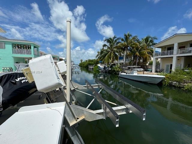 view of dock with a balcony and a water view