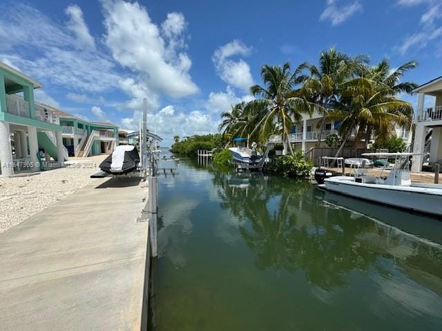 view of dock with a balcony and a water view