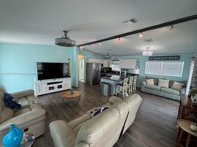 living room with dark hardwood / wood-style floors and rail lighting