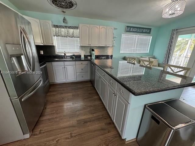 kitchen featuring appliances with stainless steel finishes, decorative backsplash, hardwood / wood-style floors, sink, and white cabinets