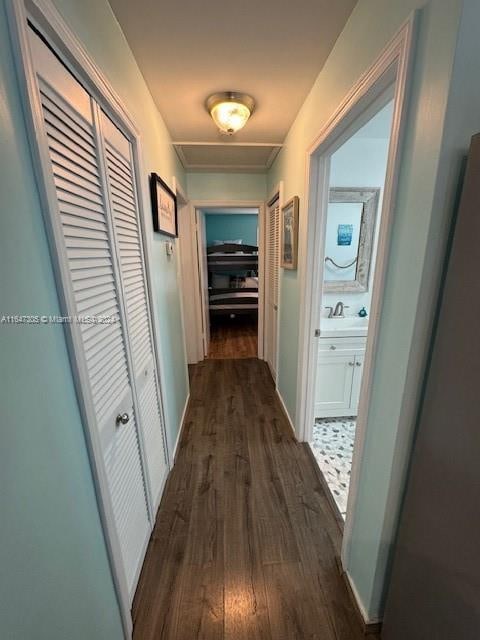 hallway with sink and dark tile patterned flooring