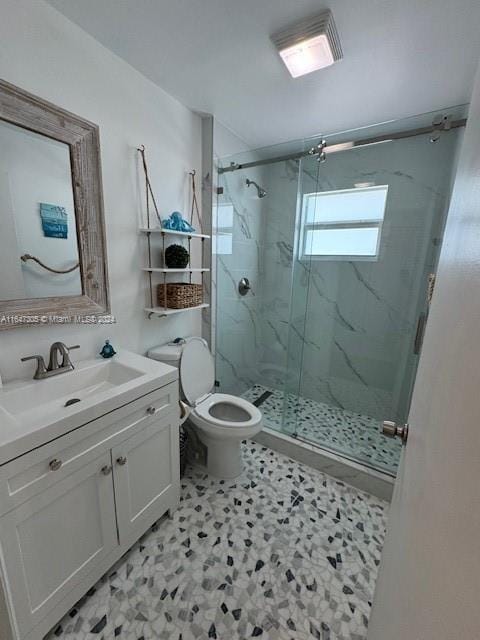 bathroom featuring tile patterned flooring, vanity, walk in shower, and toilet